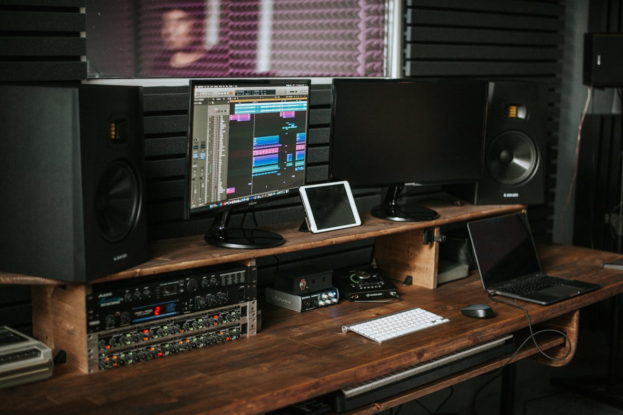 A modern music production workspace with monitors, speakers, and mixing equipment.
